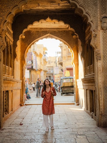 Cheerful woman exploring ornate haveli in Jaisalmer old town during...
